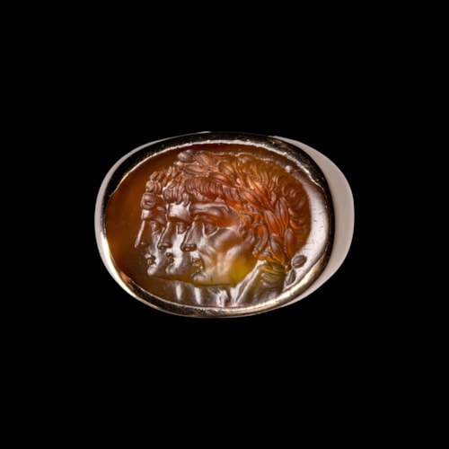 A gold ring with a Neoclassical agate intaglio. Three portraits.